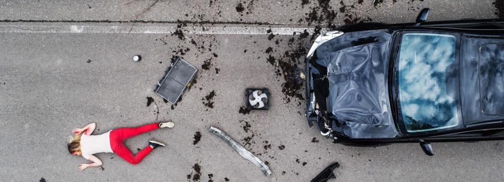 A woman lies unconscious after being hit by a car.